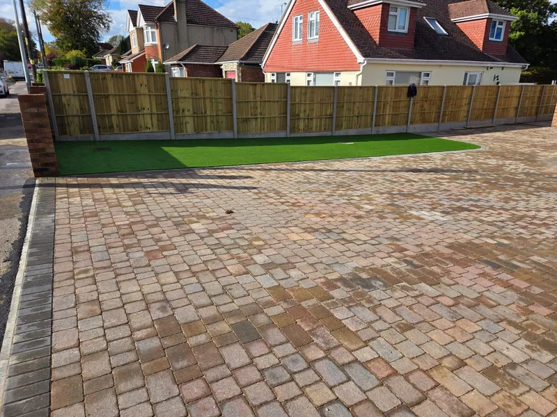 Finished brindle block paved parking area with an artificial grass border, Kent