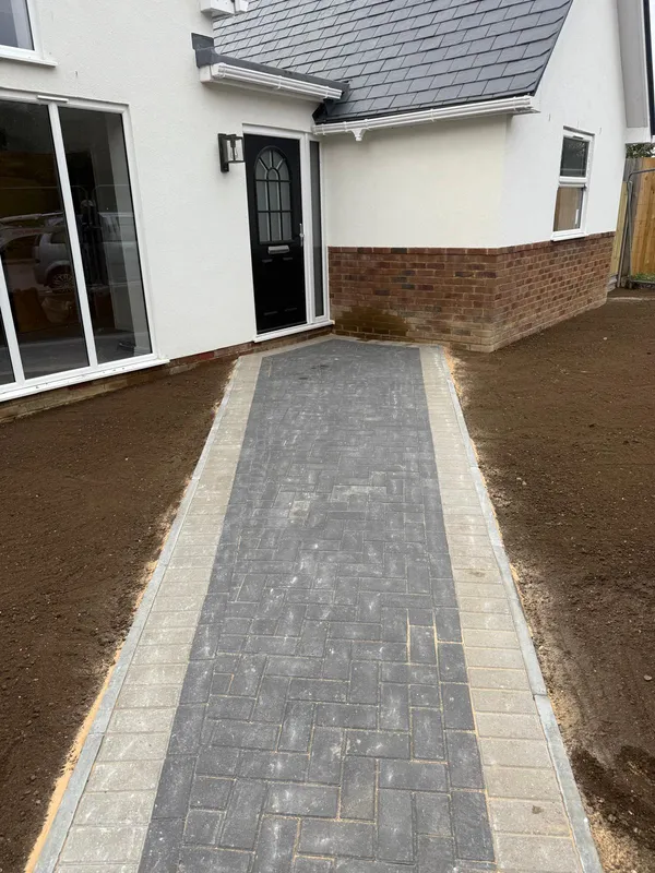Charcoal block paved path and driveway with a cream border leading to the front door, Kent