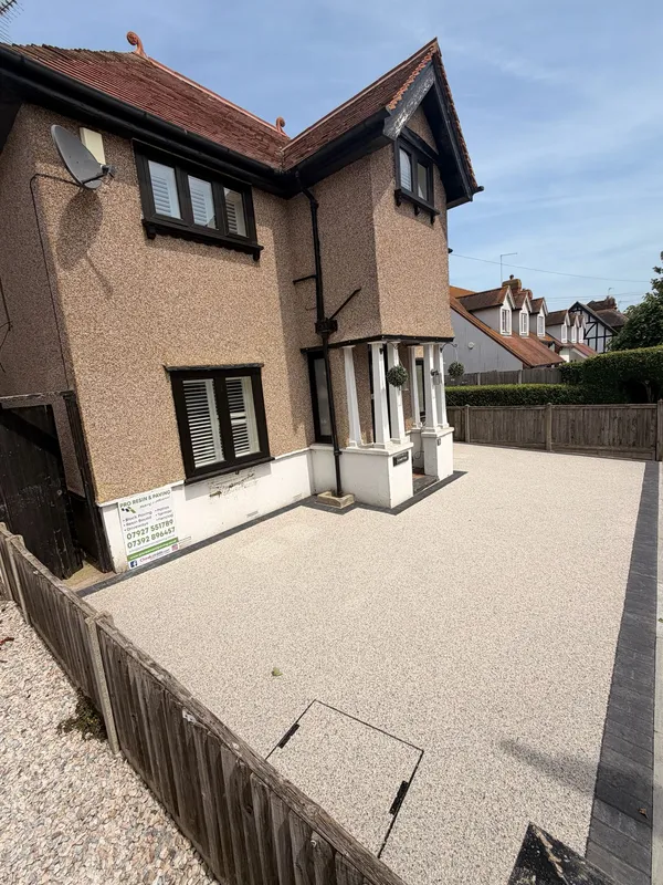 Freshly laid cream resin bound driveway curing outside a rendered house in Kent