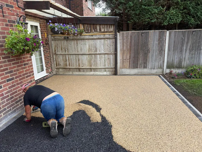 Resin bound gravel being trowelled by hand across a Kent patio area